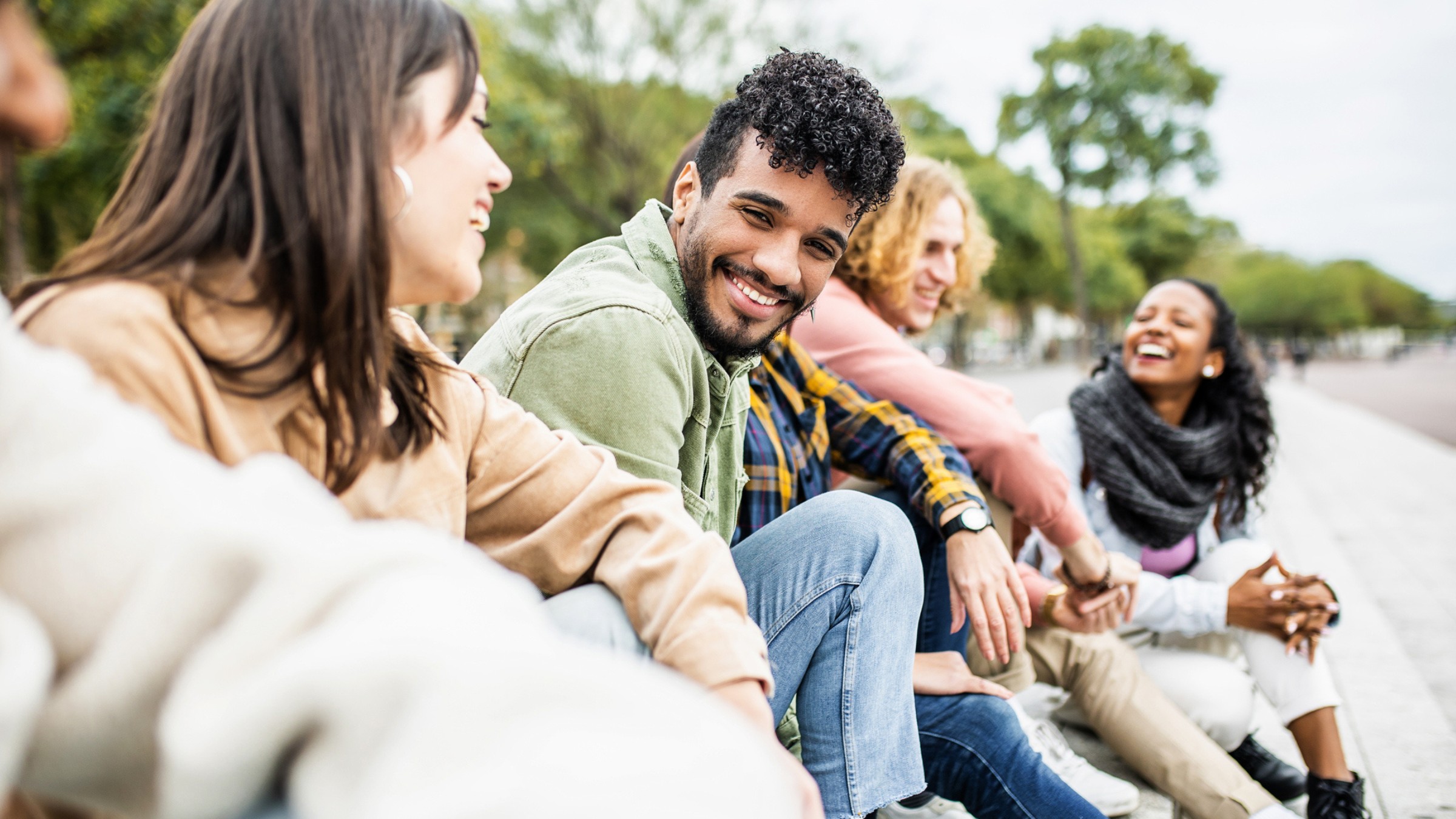 A diverse group of friends laughing together outdoors